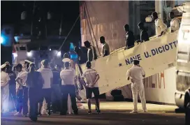  ??  ?? Some of the 67 migrants rescued at sea by the Vos Thalassa freighter disembark from the Italian coast guard ship Diciotti, in the Sicilian port of Trapani, southern Italy, to be identified by authoritie­s.