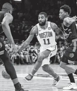  ?? Charles Krupa / Associated Press ?? Boston guard Kyrie Irving (11) had 27 points and a career-high 18 assists in the Celtics’ win over Eastern Conference-leading Toronto on Wednesday night.