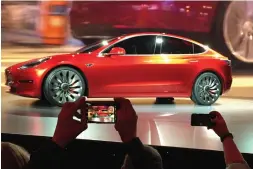  ?? Associated Press ?? Tesla Motors unveils the new lower-priced Model 3 sedan March 31, 2016, at the Tesla Motors design studio in Hawthorne, Calif.