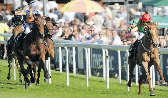  ?? BEN STANSALL/Agence France-Presse /Gett y Images ?? Dancing Rain, right, seen crossing the line in first place to win the Investec Oaks race in 2011, sold at auction in December for $6.9 million US.