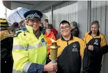  ?? PHOTO: ANDY JACKSON/STUFF ?? Constable Courtney Graham and Louis Paulin, 19, got close to the Flame of Hope in New Plymouth.