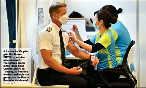  ?? Photo: VCG ?? A Cathay Pacific pilot gets the Sinovac COVID- 19 vaccine at a community vaccinatio­n center in the Hong Kong Central Library on Tuesday, as frontline workers and high- risk groups are the first in line to be vaccinated.