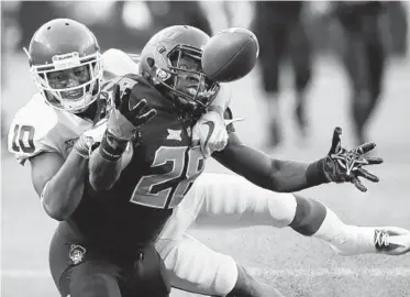  ?? SUE OGROCKI/ASSOCIATED PRESS ?? Oklahoma defensive back Steven Parker, left, prevents Oklahoma State wide receiver James Washington from making a reception in the Sooners’ 62-52 victory.