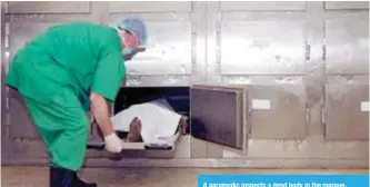  ??  ?? A paramedic inspects a dead body in the morgue.