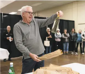  ??  ?? Bob Fraser, director of the San Francisco Chronicle Wine Competitio­n, pulls out one of the six American AgCredit Sweepstake Award winners at the end of the judging.