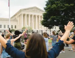  ?? STEFANI REYNOLDS/GETTY-AFP ?? People pray Monday outside the Supreme Court, which ruled 6-3 in favor of a Washington state high school football coach who knelt and prayed after games.