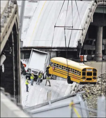  ?? NATI HARNIK/THE ASSOCIATED PRESS ?? In this Aug. 12, 2007, file photo, workers remove a school bus from the Interstate 35W bridge collapse site in Minneapoli­s. According to court testimony in a federal terrorism trial, Mohamed Roble, who was one of the passengers on the bus, is now...