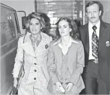  ??  ?? Patty Hearst, center, daughter of California newspaper magnate Randolph Hearst, is escorted by U.S. marshals in 1976.