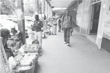  ??  ?? Defiant vendors display their wares in front of shops along Lobengula Street selling the same products that are found in the stores