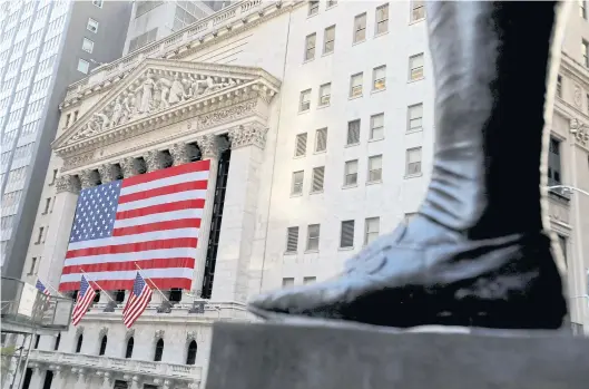  ?? REUTERS ?? The boot on the statue of George Washington, the first president of the United States, right, is seen across from the New York Stock Exchange following the Nov 4, 2020, presidenti­al election.