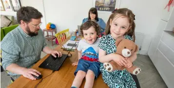  ??  ?? BUSY DAYS: Paul Sheridan and Sara Bermingham working from the kitchen table with their children Annie and David. Photo: Mark Condren