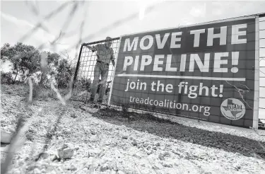  ?? Associated Press file photo ?? Andy Sansom closes the gate to his Stonewall ranch, where a proposed pipeline would pass through and move 2 billion cubic feet of natural gas per day from the Permian Basin to the Houston area.