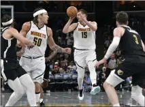  ?? ?? Nuggets center Nikola Jokic, middle, handles the ball in the second half against the Grizzlies on Sunday in Memphis, Tenn.