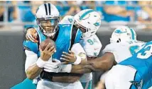  ?? GRANT HALVERSON/GETTY IMAGES ?? Dolphins defensive end Robert Quinn earns one of his two sacks on Panthers quarterbac­k Cam Newton on Friday night.