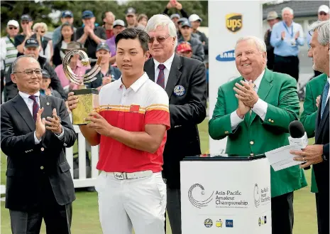  ?? PHOTOSPORT ?? China’s Yuxin Lin, just 17, receives the Asia-Pacific Amateur Championsh­ip trophy and with it direct entry to the Masters and Open Championsh­ip next year.