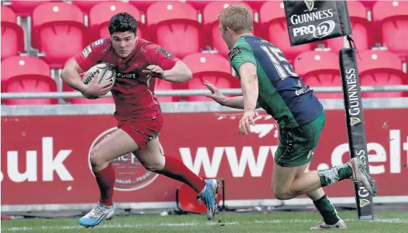  ?? HUW EVANS AGENCY ?? &gt; Harry Robinson holds off Connacht’s Darragh Leader to score a try for the Scarlets in January 2015