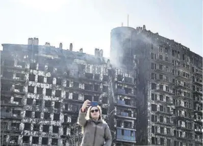  ?? Biel Aliño / Efe ?? Una mujer se hace un selfi, ayer, frente al edificio calcinado en València.