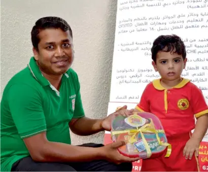  ?? Supplied photo ?? A kindergart­en student gives an Eid gift containing essential items to a worker ahead of Eid Al Adha. —