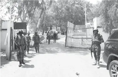  ?? — Gambar AFP ?? KAWALAN KETAT: Anggota tentera dan polis Nigeria berkawal di hadapan pintu masuk ‘Federal College of Forestry Mechanisat­ion’ di Mando.