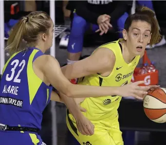  ?? AP PHotos ?? HOME STRETCH: Seattle Storm forward Breanna Stewart drives against Dallas Wings forward Bella Alarie during the first half Friday. Below, Stewart celebrates her basket against the Wings with teammates.