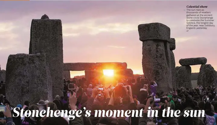  ?? AP ?? Celestial show The sun rises as thousands of revellers gathered at the ancient stone circle Stonehenge to celebrate the Summer Solstice, the longest day of the year, near Salisbury, England, yesterday.