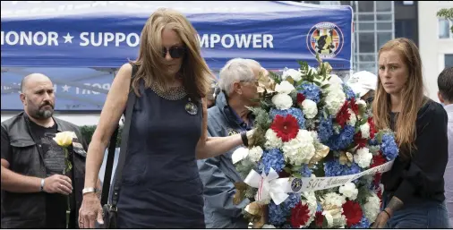  ?? (AP/Michael Dwyer) ?? Mary Ellen Callahan (left) and Kelsey Powers carry a wreath in memory of Marine Sgt. Johanny Rosario Pichardo of Lawrence, Mass., during a ceremony Saturday at the Massachuse­tts Fallen Heroes Memorial in Boston. The ceremony was held to honor the U.S. service members, including Rosario, who died in a suicide bombing at the airport in Kabul, Afghanista­n.