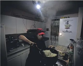  ?? CARRIE COCHRAN/ USA TODAY NETWORK ?? Michelle Rebollo cooks dinner by solar- and batterypow­ered light, using a propane camp stove, in Toa Alta, Puerto Rico, after a major power outage hit the island March 1.