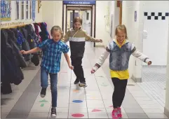  ?? NEWS PHOTO EMMA BENNETT NEWS PHOTO TIM KALINOWSKI ?? Mother Teresa students Alexis Goffinet, Kieran Wyrostok and Preslee Adriaensen show off their hopscotch skills on the school's "Don't Walk in the Hallways" obstacle course during National Child Day on Monday.