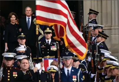 ?? The Associated Press ?? NATIONAL CATHEDRAL: Former President George W. Bush and former first lady Laura Bush, top left, watch Wednesday as the casket of former President George H.W. Bush is carried out after a state funeral at the National Cathedral in Washington.