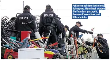  ??  ?? Polizisten auf dem Dach eines Schuppens. Meterhoch wurden die Fahrräder gestapelt, daneben Rasenmäher und Kühlschrän­ke.