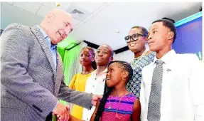  ?? IAN ALLEN/PHOTOGRAPH­ER ?? Sagicor Group Jamaica CEO Christophe­r Zacca congratula­tes four of the 43 recipients of the Sagicor Foundation Scholarshi­p at the awards ceremony held at The Jamaica Pegasus Hotel in New Kingston on Wednesday, August 9, 2023. The others, from second left, are:, Reneka Reid from Fullerswoo­d Primary School, Obrian Clarke, who is bound for Calabar High School, a smiling Sunjai Kirkpatric­k from St Aloysius Primary, Jevaughney Findlay of St Jago High, while the Ministry of Education’s deputy chief education officer Terry-Ann Thomas-Gayle looks on.