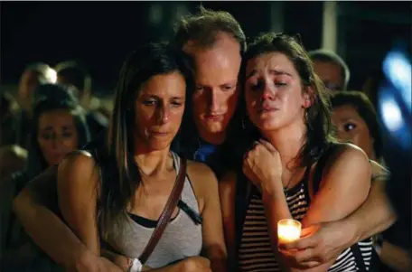  ?? CHARLIE RIEDEL — THE ASSOCIATED PRESS ?? Mallory Cunningham, left; Santino Tomasetti, center; and Aubrey Reece attend a candleligh­t vigil in the parking lot of Ride the Ducks on Friday night in Branson, Mo., for the victims of the deadly duck boat sinking,