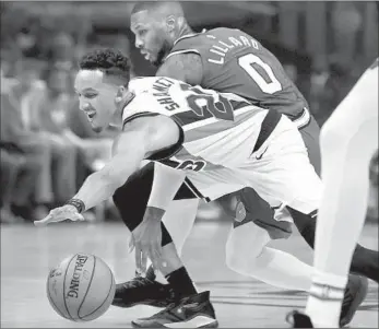  ?? Photograph­s by Luis Sinco Los Angeles Times ?? CLIPPERS guard Landry Shamet, who scored eight points, knocks the ball away from the Portland Trail Blazers guard Damian Lillard in the first quarter at Staples Center. Lillard scored 22 points.