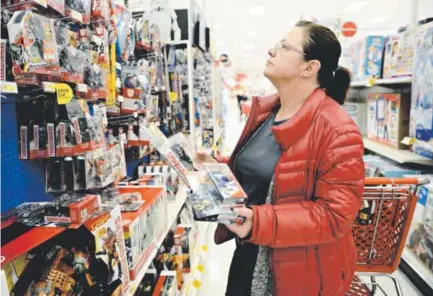  ??  ?? Peggy Senkow of Frederick shops in the toy section at a Target store in Longmont in November. After being criticized on social media, Target will make over its toy section, grouping products for girls and boys together. Lewis Geyer, Longmont Times-Call...