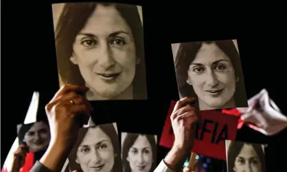  ??  ?? Placards reading ‘mafia government’ and bearing photos of killed journalist Daphne Caruana Galizia are held aloft at a protest in Valletta in 2019. Photograph: AFP/Getty Images