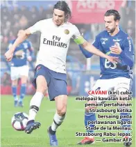  ??  ?? CAVANI (kiri) cuba melepasi kawalan ketat pemain pertahanan Strasbourg ketika bersaing pada perlawanan liga di Stade de la Meinau, Strasbourg Rabu lepas. — Gambar AFP