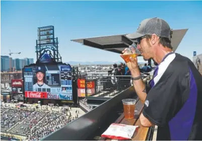  ?? Photos by Andy Cross, The Denver Post ?? Above, businessma­n Dan Schuck enjoys a cold brew from the Rooftop at Coors Field as the Colorado Rockies play the San Diego Padres on April 22. Below, Rick Pilgrim, left, and Dave Madden each got a burger, fries and a beer as part of the Business...