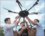  ?? YE AUNG THU / AGENCE FRANCE-PRESSE ?? Nyi Lin Seck (left) and other members of his team prepare to launch a drone above the ancient city of Bagan in central Myanmar.