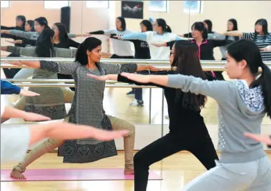  ?? LIN YIGUANG / XINHUA ?? An Indian teacher gives a yoga class to students at Yoga College of Yunnan Nationalit­ies University in Kunming, Yunnan province.