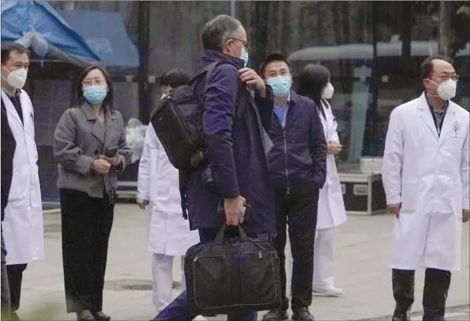  ?? Photo: AP ?? Peter Ben Embarek (center) of the World Health Organizati­on research team passes by Chinese doctors during a visit to the Hubei Provincial Hospital of Integrated Chinese and Western Medicine, also known as the Hubei Province Xinhua Hospital, in Wuhan, Central China’s Hubei Province on Friday.