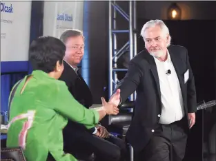  ?? Tyler Sizemore / Hearst Connecticu­t Media ?? Philip Morris Internatio­nal CEO Jacek Olczak, right, shakes hands with AdvanceCT Co-chair Indra Nooyi, left, and Gov. Ned Lamont after announcing Philip Morris Internatio­nal’s intention to move its company headquarte­rs to the area during an AdvanceCT forum discussion at The Village in Stamford on Tuesday.