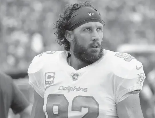  ?? WILFREDO LEE/AP ?? Dolphins long snapper John Denney checks out the action from the sidelines during the first half against the Detroit Lions on Oct. 21 in Miami Gardens. Denney was cut on Monday.