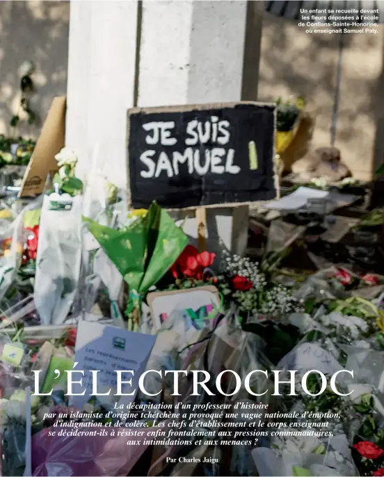  ??  ?? Un enfant se recueille devant les fleurs déposées à l’école de Conflans-Sainte-Honorine,
où enseignait Samuel Paty.