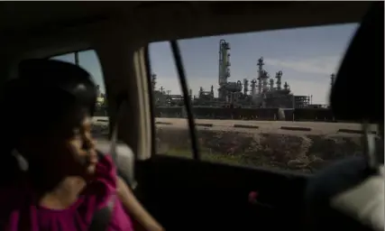  ?? Danielle Villasana for The Washington Post ?? A local resident looks from a vehicle window at a refinery in Lake Charles, La. The Environmen­tal Protection Agency issued a new rule on Tuesday that will require at least 218 chemical plants nationwide to reduce toxic emissions that are likely to cause cancer.