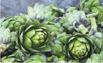  ?? David Gomez / Getty Images ?? Artichoke fields in Castrovill­e and cut artichokes in a wooden bin at a roadside stand, awaiting mayonnaise.