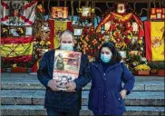  ?? MANU FERNANDEZ / AP ?? Acouple stand in front of a shrine with flowers and Spanish flagsmarki­ng the 45th anniversar­y of the death of Spanish dictator Gen. Francisco Franco at the Mingorrubi­o’s cemetery on the outskirts ofMadrid on Nov. 20.