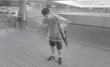  ?? AGENCE FRANCE PRESSE ?? A man tries to walk against the winds from Typhoon Hato in Hong Kong’s Central district.