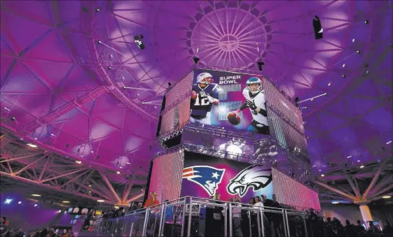  ?? Heidi Fang Las Vegas Review-Journal @HeidiFang ?? A banner featuring Super Bowl LII quarterbac­ks Tom Brady of the New England Patriots, left, and Nick Foles of the Philadelph­ia Eagles at the NFL Experience on Friday at the Minneapoli­s Convention Center in Minneapoli­s.