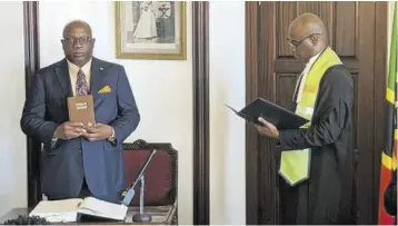  ?? ?? In this June 7, 2020 file photo, Dr Timothy Harris (left) is sworn in as prime minister of St Kitts-nevis for a second five-year term, after his Team Unity Coalition won the general elections. Administer­ing the oath is resident High Court judge in St Kitts His Lordship Justice Trevor Ward. The swearing-in took place at Government House, the official residence of the governor general.