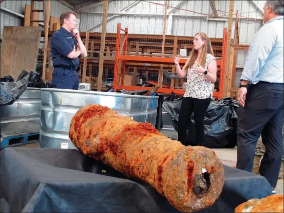  ?? (AP/Russ Bynum) ?? Commodore Philip Nash (left) of the British Royal Navy gets a briefing Thursday from U.S. Army Corps of Engineers archaeolog­ist Andrea Farmer in Savannah, Ga., about 19 cannons recovered from the Savannah River, that experts suspect came from one or more British ships scuttled in the river during the American Revolution in 1779.